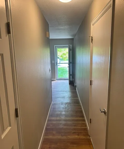 Hallway from kitchen to front door, living room and garage, to the right.