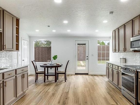 Kitchen with tasteful backsplash, stainless steel appliances, light stone countertops, light wood-style flooring, and recessed lighting