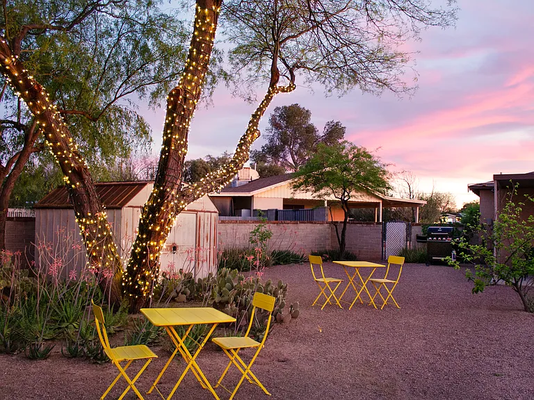 Private backyard with seating, string lights, and sunset views.