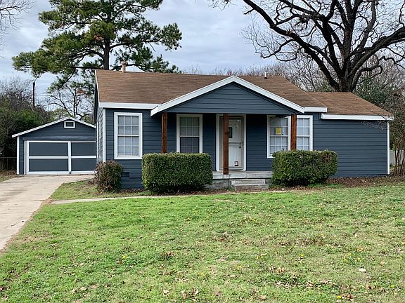 Detached two car garage with extra storage and shelving.