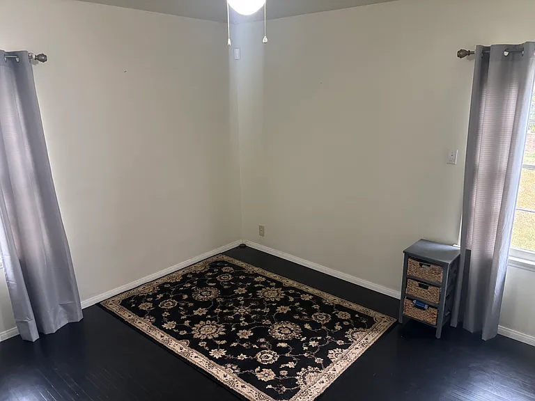 One of two spacious bedrooms featuring two large windows, a generous closet, beautiful wood flooring, and a ceiling fan.