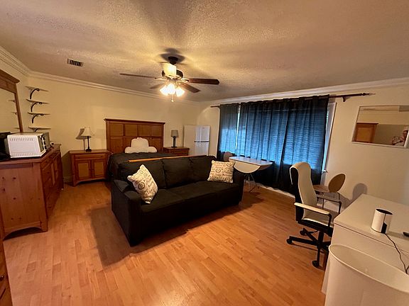 Furnished room with bed set, couch, desk, smart TV, full bathroom, walk in closet, and private entrance