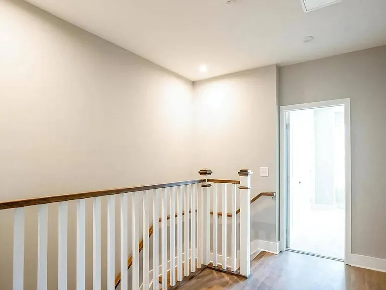 Modern Two-Story Apartment Interior Featuring Open Railing and Natural Light