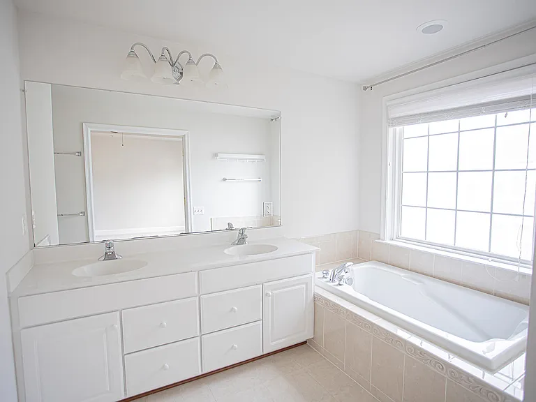 Spa-like master bathroom with double vanities, lots of storage, oversized mirror, dreamy bathtub and a separate shower