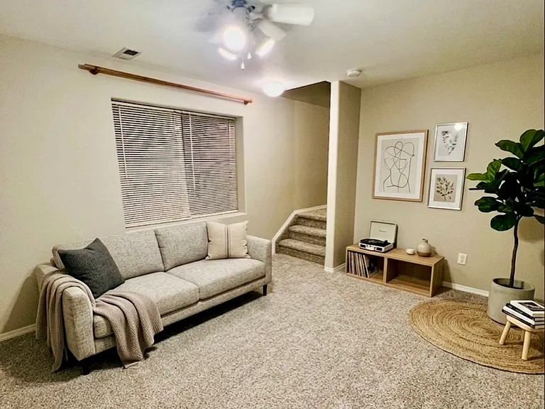 Finished basement living area, virtually staged to show possible furniture placement