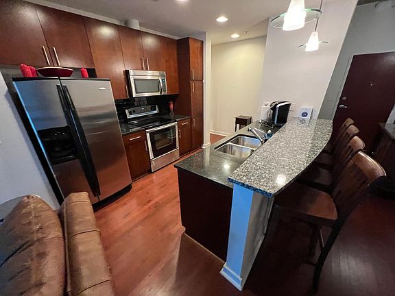 Kitchen with refrigerator and appliances. (Furnished view.)