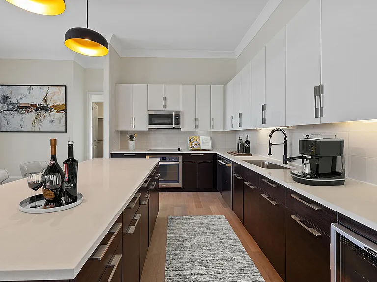 An upgraded penthouse kitchen that makes a statementfeaturing expansive countertops, custom cabinetry, modern lighting, and a sleek, contemporary layout designed for elevated everyday living and effo