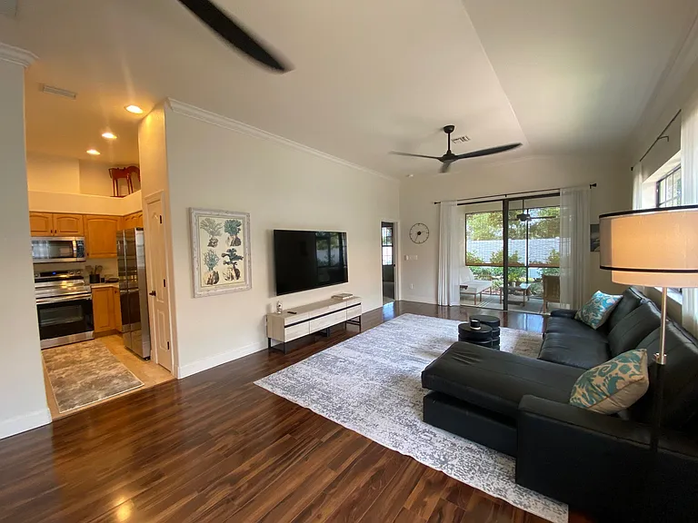 Living room with ceiling fans, high ceilings and open to kitchen