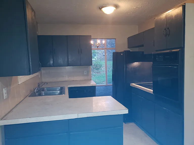 upgraded smoke gray cabinets and black appliances in Butler's kitchen