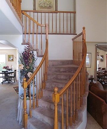 Front entry view. Curved staircase. Spacious vaulted ceilings. Open floor plan.
