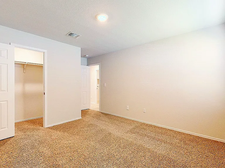 Comfortable 3rd bedroom featuring soft carpet, a spacious walk-in closet, and natural light.