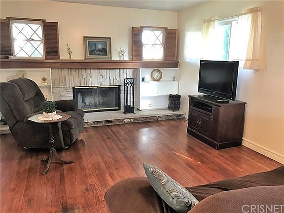 Gorgeous hardwood floors & stone fireplace with large wood mantle & stone and concrete hearth