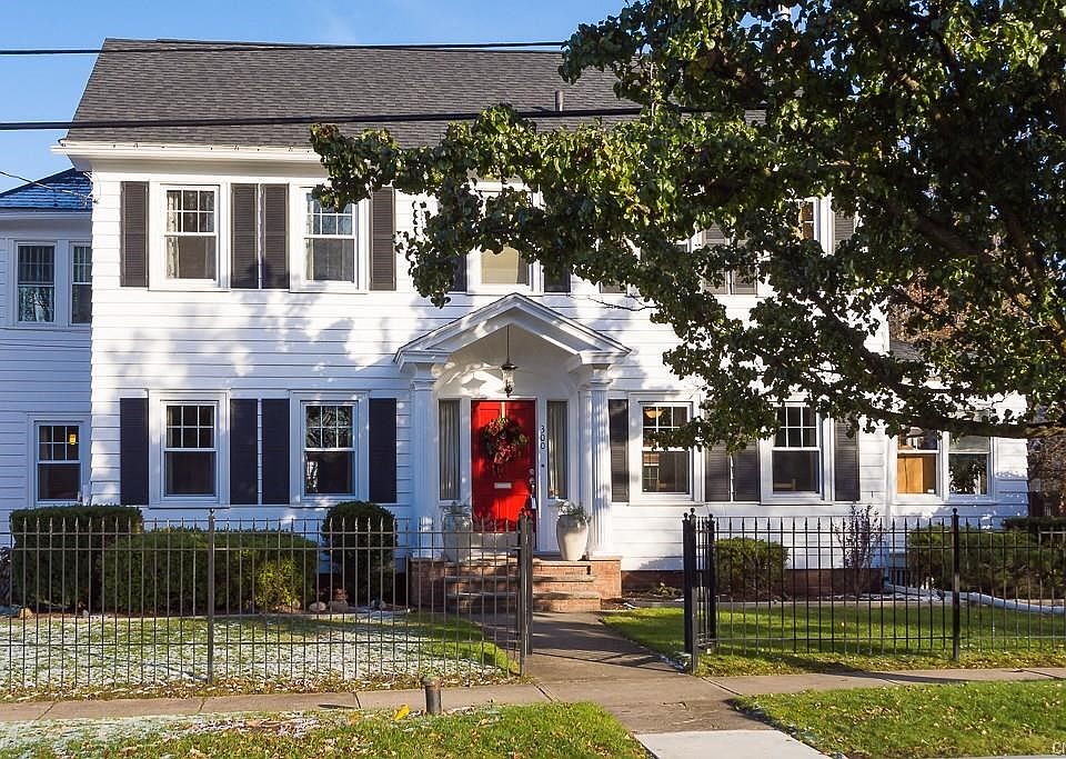 Black wrought iron fence surrounds this handsome Sedgwick Colonial on corner lot with enclosed porches.