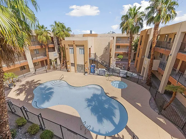 Experience resort-style living with this inviting courtyard's sparkling pool and lush palm surroundings.