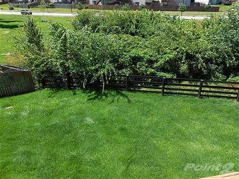 View of backyard from the deck.  Greenspace behind the home.