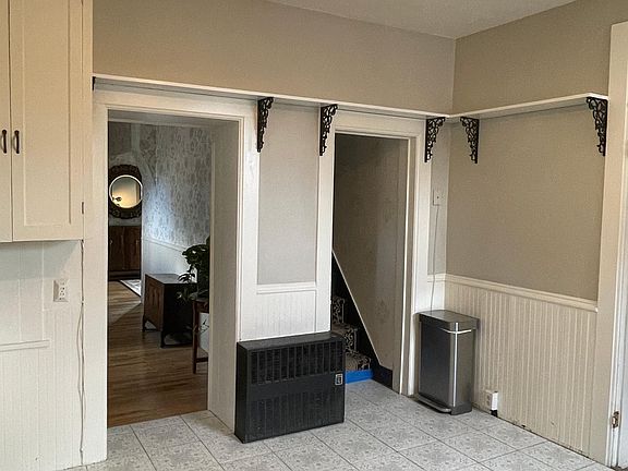 Refrigerator will be placed next to trash can in this photo.