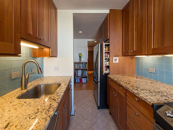 renovated kitchen with stainless steel appliances, granite counters, bosch stacked washer and dryer