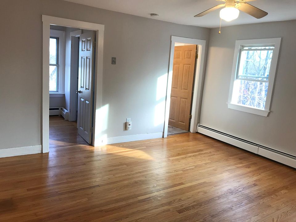 Living room with hardwood floors and lots of natural light coming in from the large windows. Brand new paint in entire apartment.