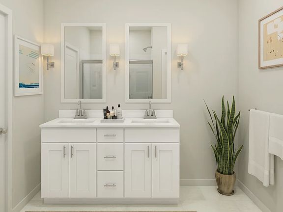Primary bath with chrome fixtures and white framed mirrors