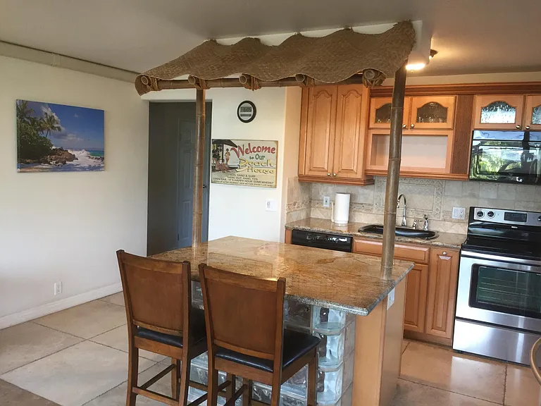 Kitchen with island seating and granite counters.