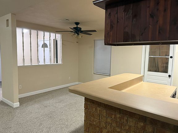 open concept dining room area with front window and door to garage