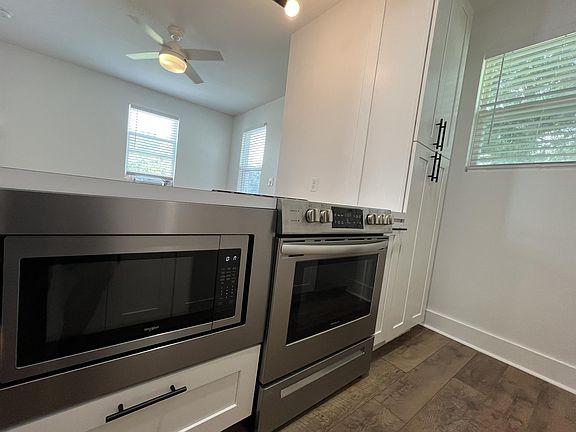 Stainless steel built-in microwave and a slide in stove/oven, with glass top.