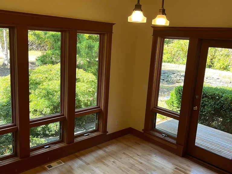 Spacious home office with nature right outside expansive windows.