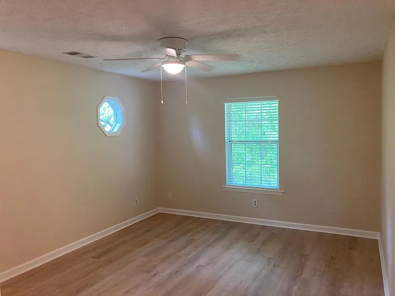 Large master bedroom, private, surrounded by trees includes private bath and walk-in closet.