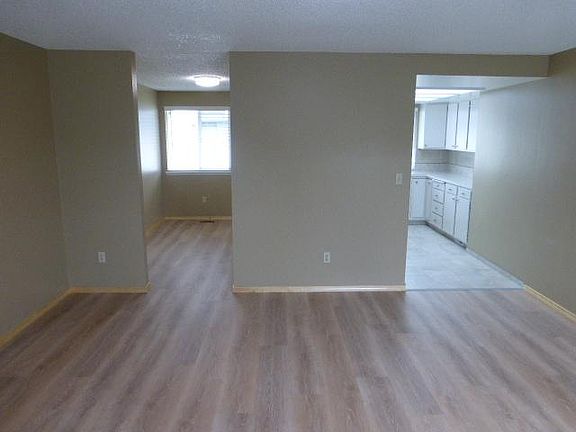 Roomy kitchen on the right, dining room on the left leads to the private fenced backyard and garage entry.