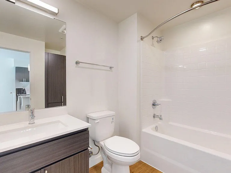 Apartment Bathroom with large soaking tub and wood-style flooring.