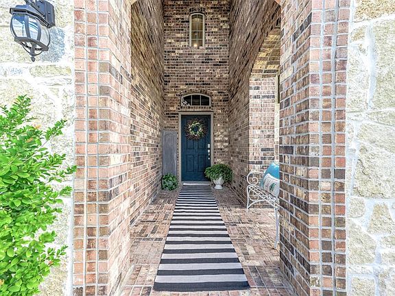 A long walkway is mesmerizing and brings us through elegant brick arches, all the way up to the gorgeous dark stained front door!