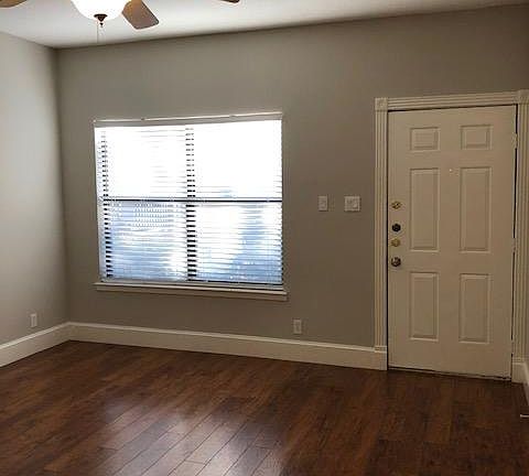 Spacious living room with large window looking out on courtyard & pool.