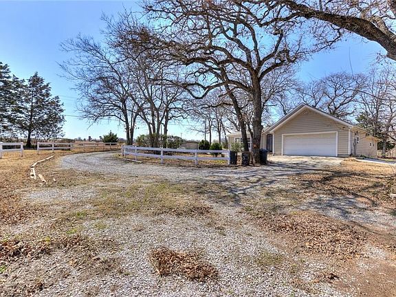 View of the driveway, garage from the red barn on property.