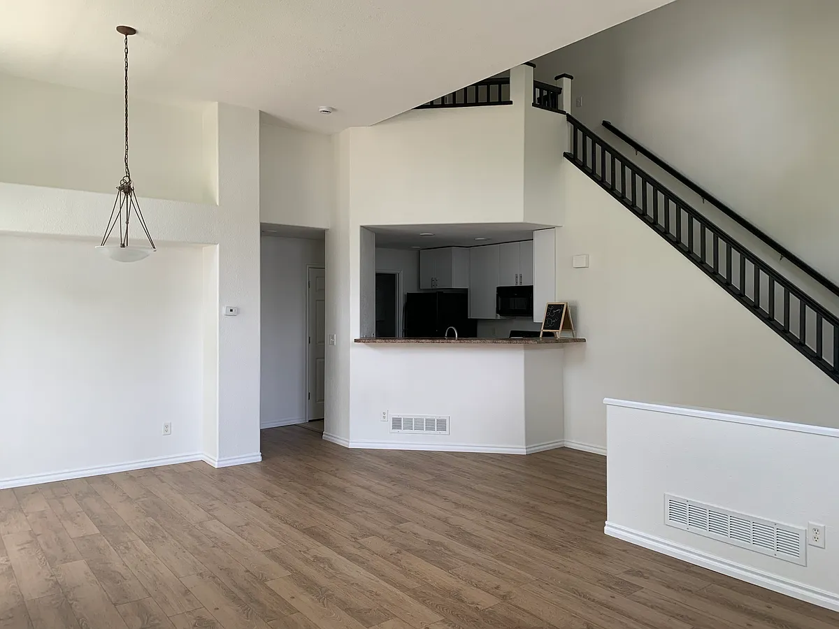 Family room/dining room with view of kitchen and stairs to second floor - 3000 E 112th Ave #25