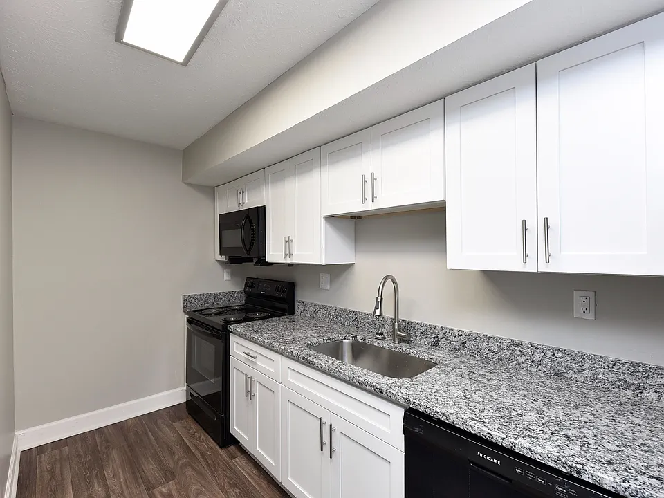 Kitchen with granite counters, black appliances, and modern cabinetry