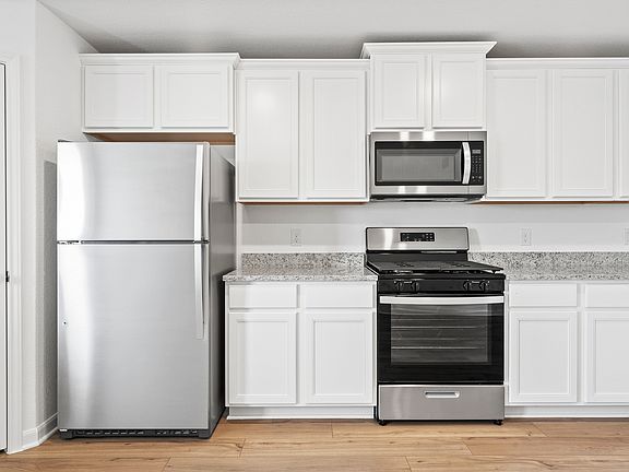 The kitchen is sure to impress with white cabinetry and granite countertops.