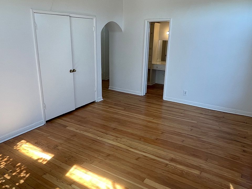 living room looking into bathroom (door) and arch into entry hall