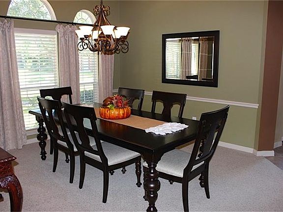 The formal dining has a bronze chandelier and chair rail mol