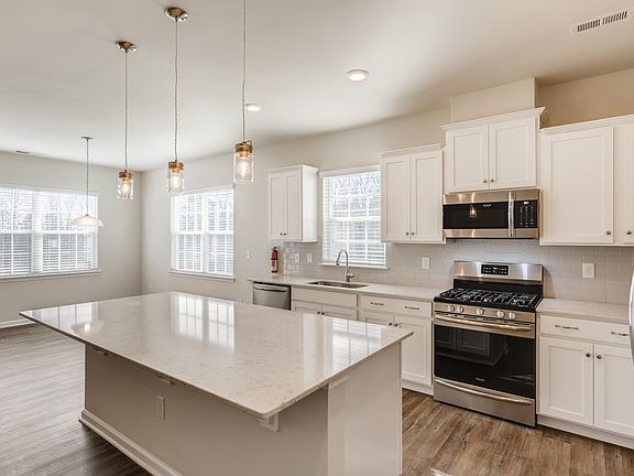 Quartz counters, stainless appliances, modern pendant lights.