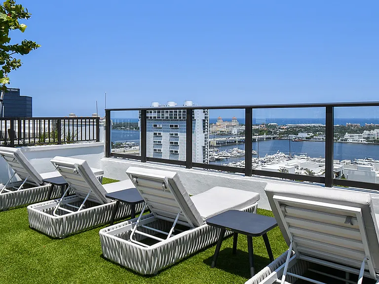 Griffis West Palm apartments rooftop deck with turf lawn and lounge chairs overlooking West Palm Beach.
