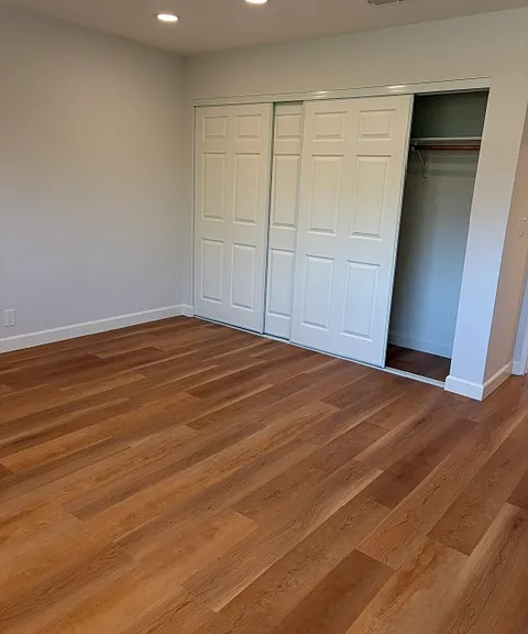 Upper level primary room closet with 3 sliding doors