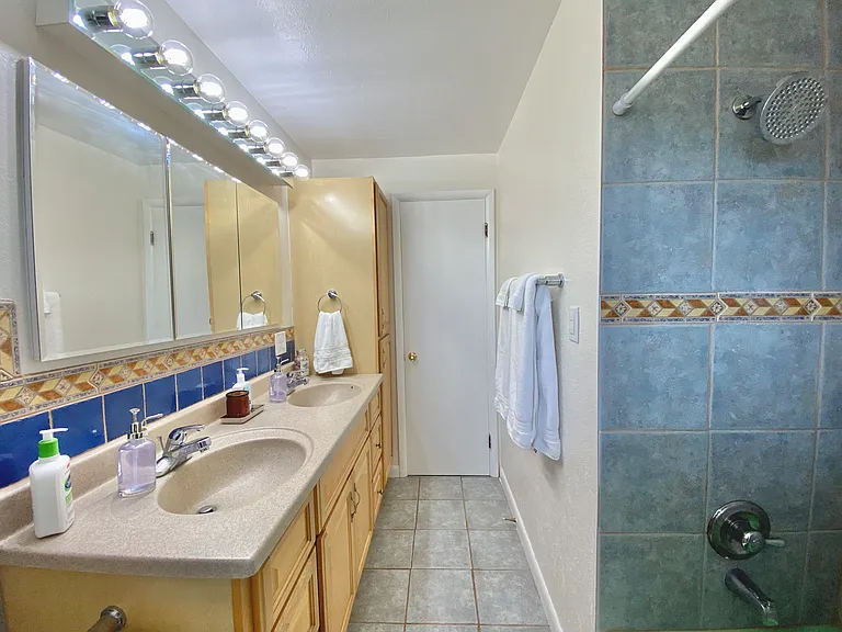 Main level full bathroom (shower/tub combo) with dual sinks