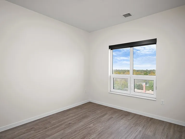 Bright and airy room with large window offering scenic views, featuring sleek wood flooring and modern, minimalistic design. Bright and airy room with large window offering scenic views, featuring sleek wood flooring and modern, minimalistic design.