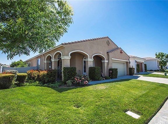 Healthy front lawn and front porch entry with archways