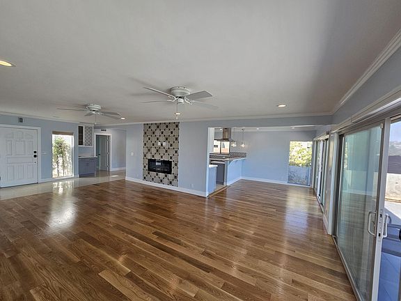 Living area with floor to ceiling tiles and electric fire place. Open to bar area.