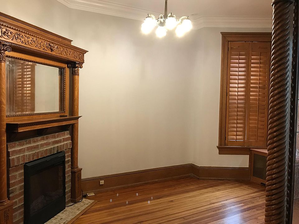 Parlor with original mantle piece, electric fireplace (new), and 3 huge windows open to a quiet street. Parlor can be used as a separate living room or office space.