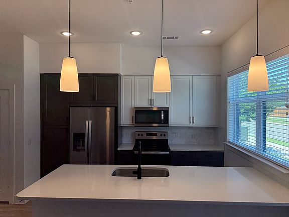 Large quartz kitchen counter top with open sightlines to living room