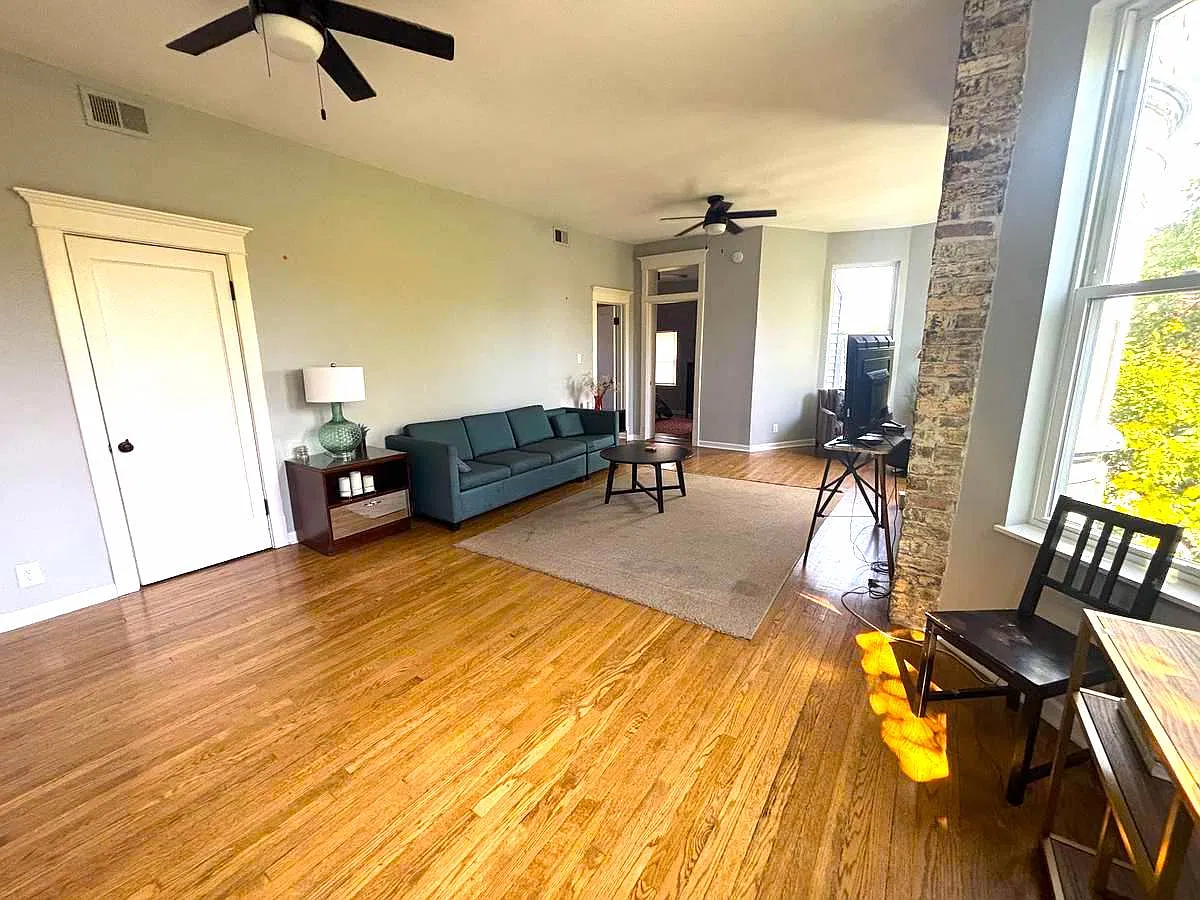 Combination living room dining room with some exposed Brick, tall ceilings and two full bay windows!