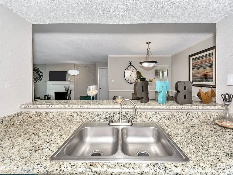 Functional kitchen featuring double-basin sink, granite-style countertops, and ample prep space.