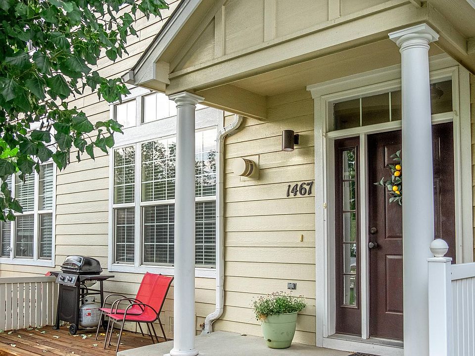 Front entrance with private fenced yard and small deck. Large shade tree.
